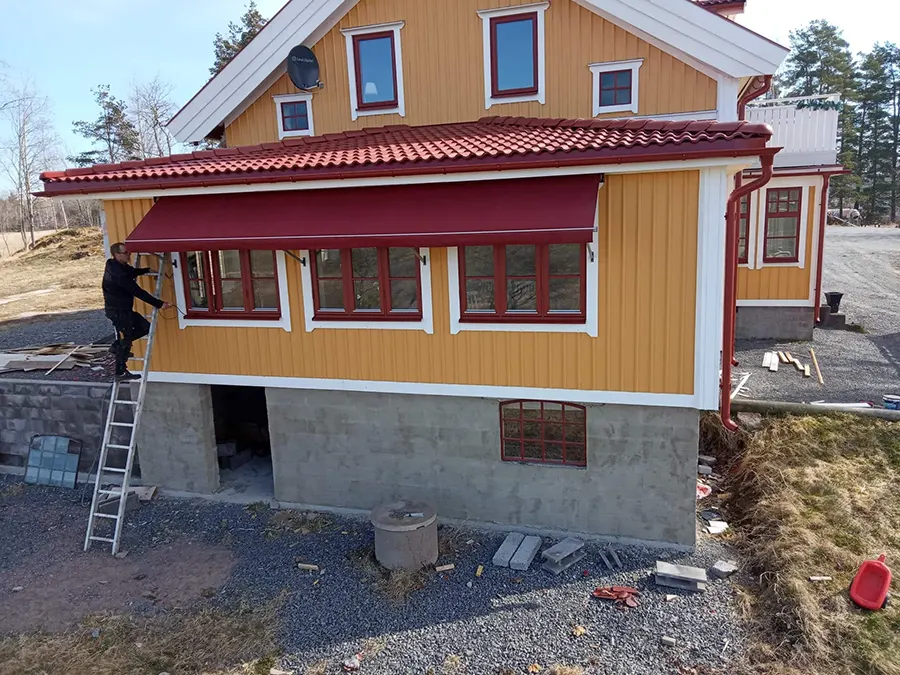 Gult hus med röd markis, som byggfirma i Säffle har satt upp.